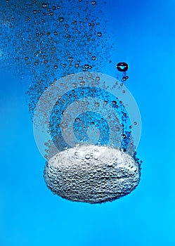 Effervescent tablet in water with bubbles