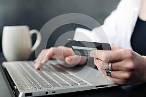 Effortless E-commerce: Woman& x27;s Hand Balancing Credit Card and Laptop. Seamless Online Shopping: Woman& x27;s Hand