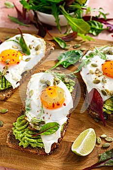 Egg and avocado toast, sandwiches with eggs and fresh greens