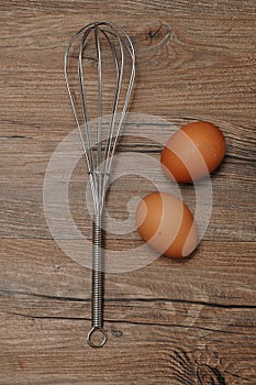 An egg beater, with two eggs