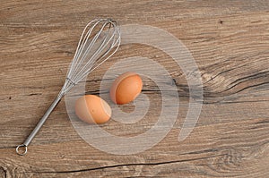 An egg beater, with two eggs