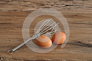 An egg beater, with two eggs