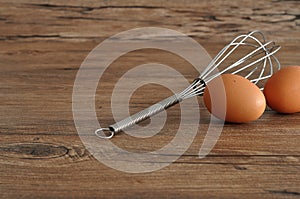 An egg beater, with two eggs