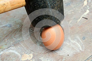 Egg being smashed or cracked with a hammer