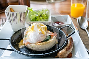 Egg benedict with bacon and sausage