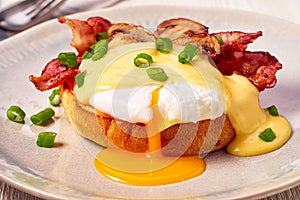 Egg Benedict with fried bacon and hollandaise sauce photo