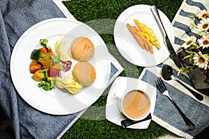 Egg Benedict slider with vegetable salad include tomato, potato, lettuce leaf and carrot with tea, coffee, and sweet melon served