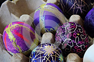 An egg carton holding decorated easter eggs