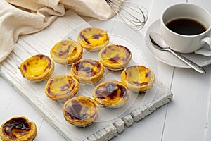 Egg custard tart dessert on wooden plate.