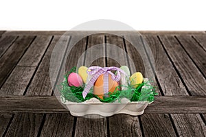 Egg in a easter nest with small eggs on a table.