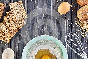 Egg in the flour, bakery ingridients for bread, pizza or pie making ingridients, food flat lay on wooden kitchen table background
