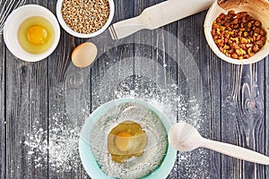 Egg in the flour, bakery ingridients for bread, pizza or pie making ingridients, food flat lay on wooden kitchen table background