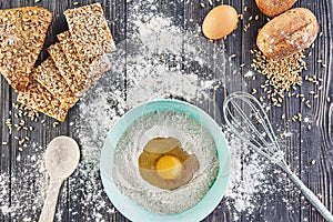 Egg in the flour, bakery ingridients for bread, pizza or pie making ingridients, food flat lay on wooden kitchen table background