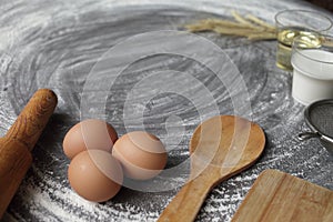 Egg, flour, olive oil, milk, wheat ears, kitchen tool on gray table background