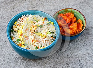Egg fried rice with sweet and sour chicken served in bowl isolated on background top view of asian food