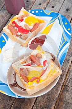 Egg, hotdog and crab stick in a hole of bread