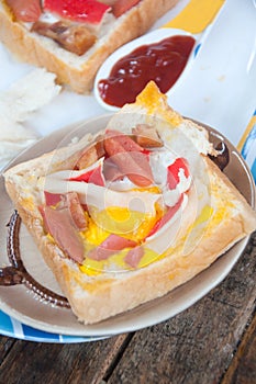 Egg, hotdog and crab stick in a hole of bread