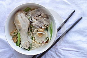 Egg Noodle with Chicken Drum Stick in a bowl and chopsticks.