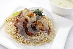 Egg noodle topped with stir fried ham and seafood