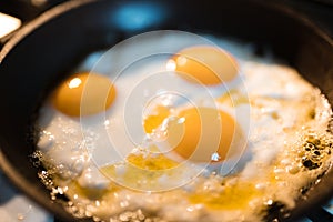 Egg omelette is being prepaired in a frying pan close up - Three yellow eggs in Eastern Europe Latvia Riga