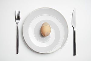 Egg on plate with knife and fork