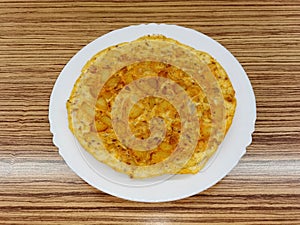 Egg and potato omelet, fried and placed on a white ceramic plate