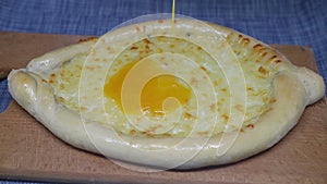 Egg is poured on khachapuri Georgian cheese pastry