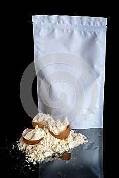 Egg protein powder heap and egg shells, white package mock up with copy space, isolated on black background