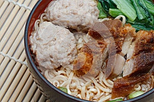 Egg rice noodles served with crispy pork and pork ball bounce.