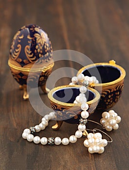 Egg shaped casket with a pearl necklace and earrings