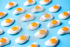 Egg shaped sweet candies on a blue background. Overhead view