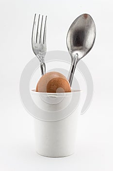 Egg with a spoon,fork in a glass of white backgrou