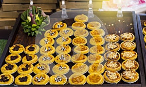 Egg tart with variety topping on wooden tray