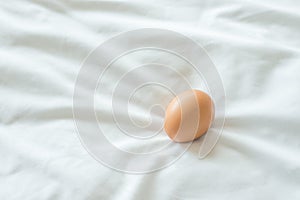 Egg on white fabric background.