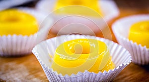Egg yolk candy, called Quindim in Brazil, and Portugal in brisa-do-Lis. Sweet dessert on rustic wooden background photo