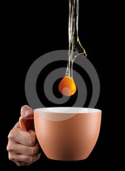 Egg Yolk dripping in to cup.