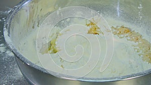 Egg yolk falls into the bowl of flour
