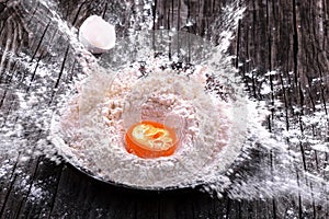 Egg yolk fell into a clay bowl with flour