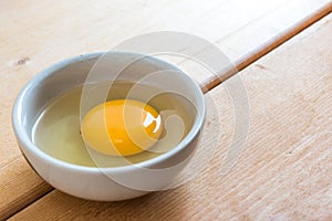 Egg Yolk In White Bowl And Eggshell