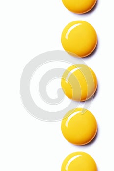Egg yolks aligned in a row on white background