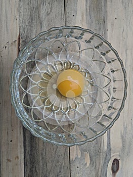 egg yolks in a glass bowl on a wooden table