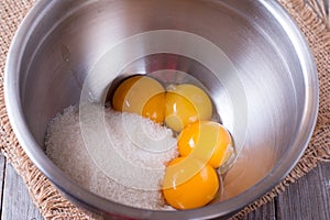 Egg yolks and sugar in metal bowl