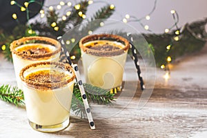 Eggnog with cinnamon and nutmeg for Christmas and winter holidays. Homemade eggnog in glasses on wooden table surface, shallow