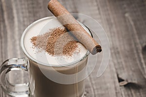 Eggnog in a glass on a wooden background with cinnamon/eggnog in