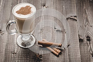 Eggnog in a glass on a wooden background with cinnamon/eggnog in