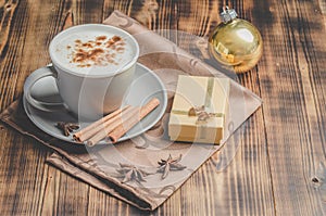 Eggnog. Traditional christmas cocktail, cinnamon sticks on a napkin and with decorations gift box and christmas toy. Wooden