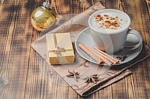 Eggnog. Traditional christmas cocktail, cinnamon sticks on a napkin and with decorations gift box and christmas toy. Wooden