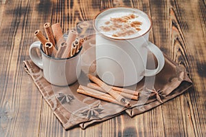 Eggnog. Traditional christmas cocktail and cinnamon sticks on napkin on wooden table