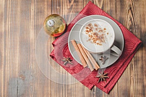 Eggnog. Traditional christmas cocktail, cinnamon sticks on a red napkin and christmas toy. Wooden background. Top view