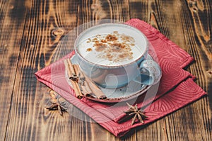 Eggnog. Traditional christmas cocktail, cinnamon sticks on a red napkin. Wooden background